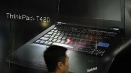 A man walks near an advertisement of Lenovo computer at a shopping center in Hong Kong, Feb. 9, 2012.