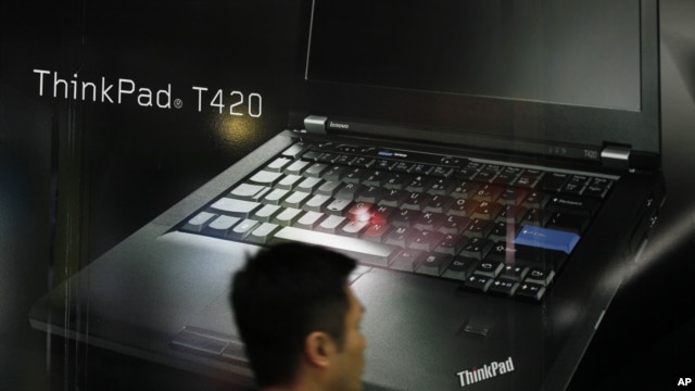 A man walks near an advertisement of Lenovo computer at a shopping center in Hong Kong, Feb. 9, 2012.