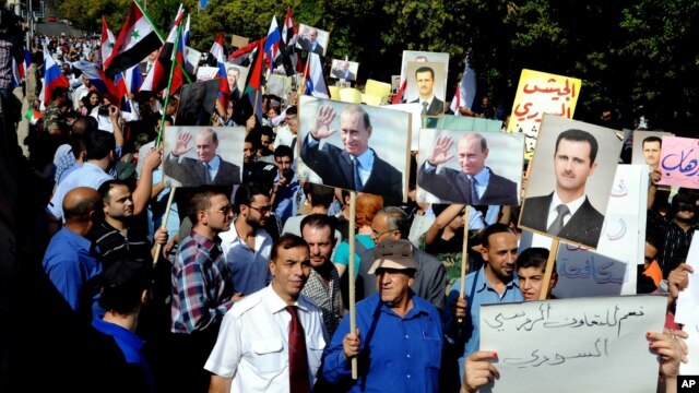 Сирийцы держат фотографии Башара Асада и Владимира Путина, во время митинга у российского посольства. Дамаск, Сирия, 13 октября 2015.