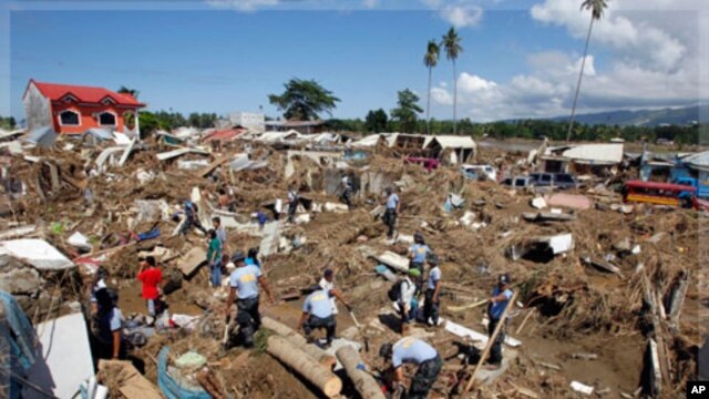 Policemen search for missing Typhoon Washi victims in a subdivision in Iligan city, southern Philippines. Disaster agencies on Monday rushed to deliver body bags, food, water, and medicine to crowded evacuation centers in the southern Philippines as offic
