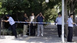 Chinese police officers set up a cordon for journalists outside the gate to the Japanese Embassy ahead of talks between Japan and North Korea in Beijing, August 29, 2012.