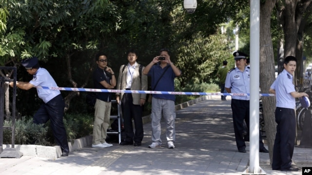 Chinese police officers set up a cordon for journalists outside the gate to the Japanese Embassy ahead of talks between Japan and North Korea in Beijing, August 29, 2012.