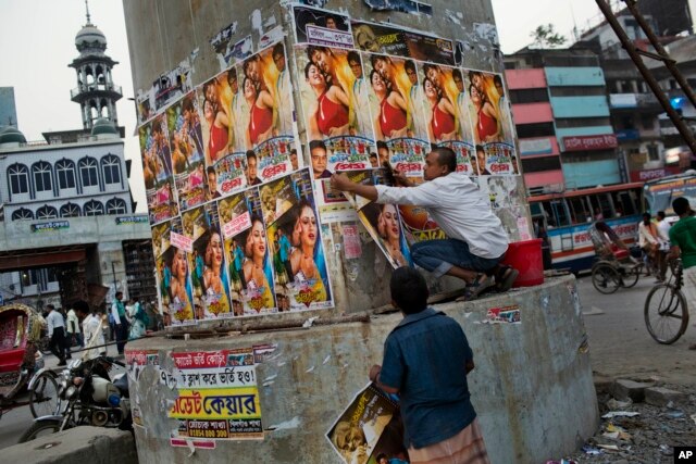 FILE - A Bangladeshi man glues movie posters in Dhaka, Bangladesh, Nov. 5, 2015. Fear ran high following months in which four bloggers and three other people were killed.
