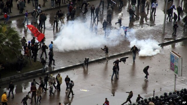 Opponents of Egyptian President Mohamed Morsi clash with Islamist supporters of the president, unseen, as a cordon of riot police separates the groups in Alexandria, Egypt, December 21, 2012.