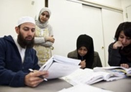 Students (from left to right) Waqas Ahmed, Sifat Reazi and Armaan Siddiqi consult with teacher Souhad Zendah (standing).