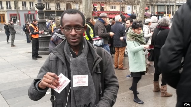 Slimane Tirera passing out anti-discrimination flyers. (Lisa Bryant/VOA)
