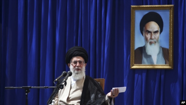 Iranian supreme leader Ayatollah Ali Khamenei delivers a speech, during a ceremony marking the 23rd death anniversary of the late revolutionary founder Ayatollah Khomeini, shown in the poster at right, at his mausoleum, just outside Tehran, Iran, June 3, 