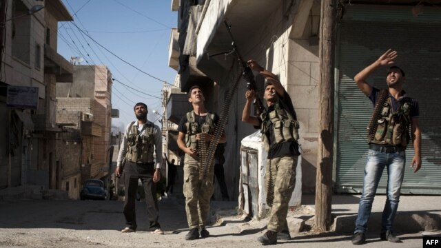 Free Syrian Army fighters train a gun on a Syrian war plane in the Bustan Pasha neighborhood of Syria's northern city of Aleppo, Aug. 23, 2012. 