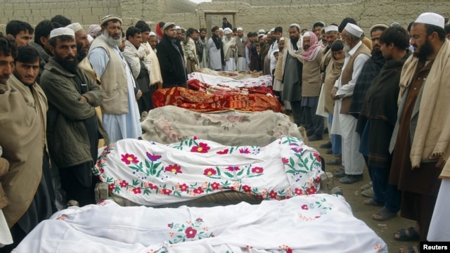 Villagers stand around the bodies of girls who were killed by an explosion in Jalalabad, Afghanistan, December 17, 2012. 