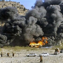 Residents look at burning oil tankers carrying fuel supplies for NATO forces, caused by a militant attack near Jamrud, in the Khyber tribal region along the Afghan border, 20 Dec 2010