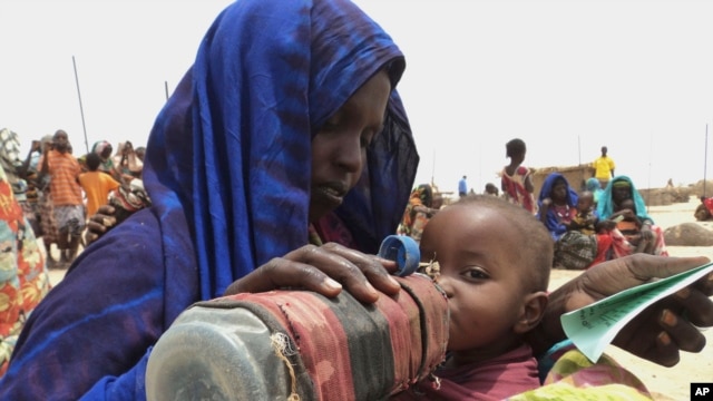 FILE - A mother quenches her malnourished child's thirst while waiting for food handouts at a health center in drought-stricken remote Somali region of Eastern Ethiopia, also known as the Ogaden.