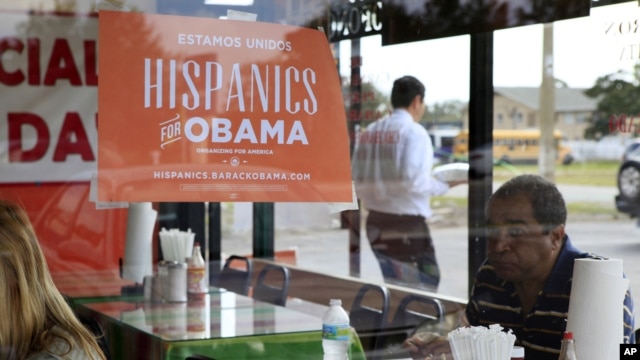 Spanish language election campaign signs promoting President Barack Obama hang on the windows at Lechonera El Barrio Restaurant in Orlando, Florida, October 26, 2012. 