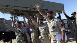 Iranian navy personnel celebrate after successfully launching a Ghader missile from the Jask port area on the shores of the Sea of Oman during a drill, January 1, 2013.
