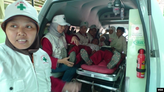 Aid workers and students simulate an earthquake evacuation at Jejeran Islamic Elementary School in Bantul, Central Java, Indonesia, October 22, 2012. (S. Schonhardt/VOA) 
