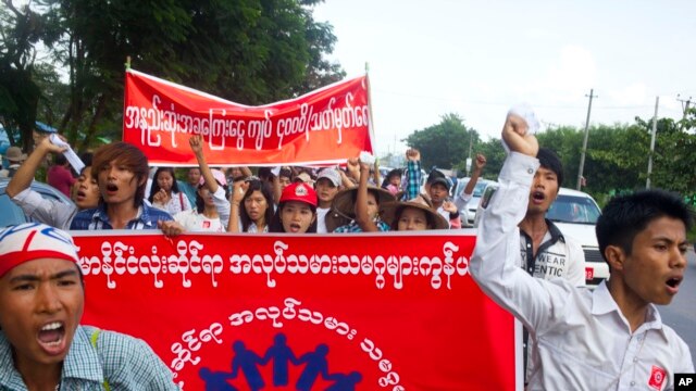 Công nhân làm việc tại nhà máy ở Myanmar giơ áp phích 'Mạng lưới Công nhân Myanmar, Có ít nhất 4.000 kyat một ngày' trong cuộc biểu tình ở thị trấn Hlaingtharyar, ngoại ô Yangon, 12/7/2015.