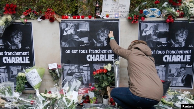 Người dân đặt hoa phía trước văn phòng báo Charlie Hebdo ở Paris, ngày 8/1/2015.