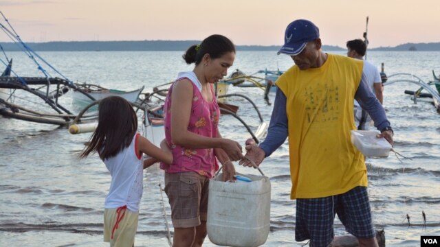 Gia đình ngư dân Philippines chuẩn bị cho một chuyến đánh cá qua đêm tại thị trấn Masinloc (Ảnh: S. Orendain/VOA)