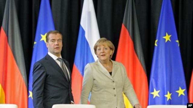 Russian President Dmitry Medvedev (L) and German Chancellor Angela Merkel arrive for a signing ceremony after a round of German-Russian consultations in Hanover, Germany, July 19, 2011