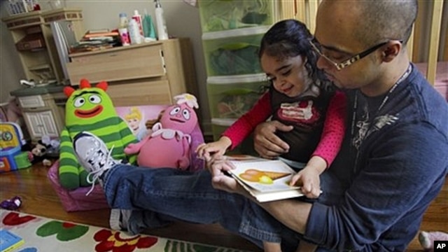 Christopher Astacio reads with his daughter Cristina, 2, who was recently diagnosed with a mild form of autism, New York, March 28, 2012.