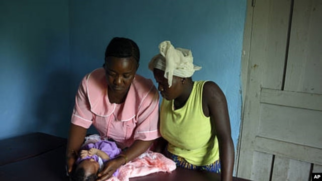 Margaret, MCHaid at Pendembu clinic examines a new born in Kallahun, Sierra Leone