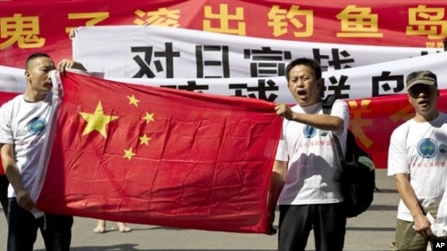 Chinese protesters hold banners reading "Declare war against Japan" and "Japan get out of Diaoyu islands" during a protest outside the Japanese Embassy in Beijing Aug. 15, 2012. 