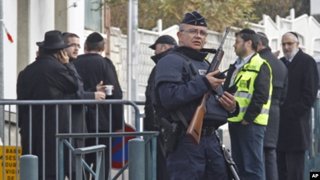 An armed police officer stands guard at the entrance of the Ozar Hatorah Jewish school in Toulouse, southwestern France, March 20, 2012.