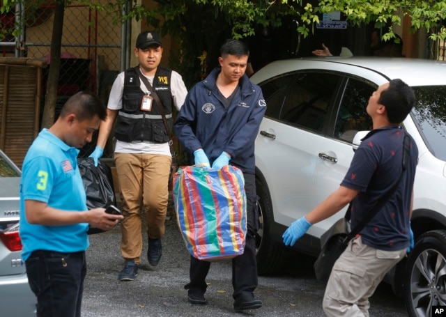 Thai policemen take evidence at an apartment on the outskirts of Bangkok on Saturday, Aug. 29, 2015.