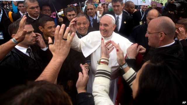 People greet the Pope as he visits the Varginha slum in Rio de Janeiro, Brazil, July 25, 2013.