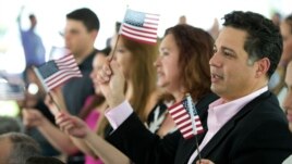 Tân công dân cầm cờ Mỹ trong buổi lễ tuyên thệ nhập quốc tịch ở trường đại học quốc tế Florida ngày 6/7/2015.