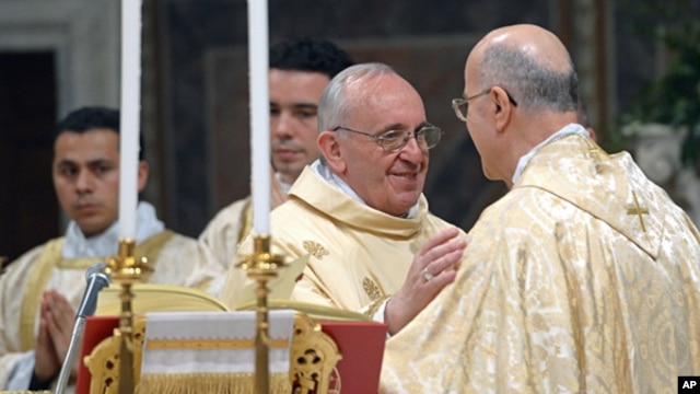 Pope Francis greets Secretary of State Cardinal Tarcisio Bertone (r) as he celebrates his inaugural Mass with cardinals, inside the Sistine Chapel at the Vatican, March 14, 2013. 