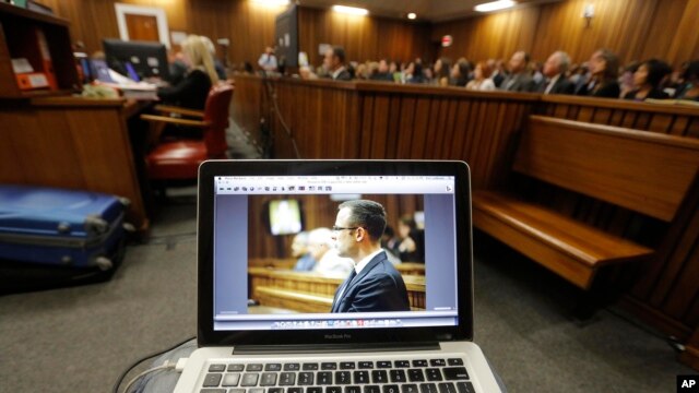 Oscar Pistorius is viewed on a laptop as he sits in the dock in court in Pretoria, South Africa, March 14, 2014.