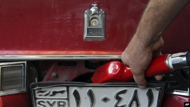 A Syrian gas station attendant fills up a car in Damascus (file photo)