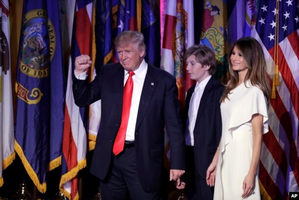 President-elect Donald Trump pumps his fist after giving his acceptance speech as his wife Melania Trump, right, and their son Barron Trump follow him during his election night rally, Nov. 9, 2016, in New York.