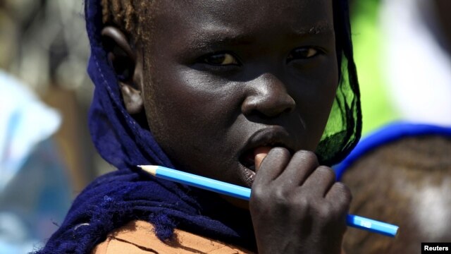 FILE - A girl waits to receive food provided by the United Nations' World Food Programme at a camp for internally displaced persons in Azaza, east of Ad Damazin, capital of Blue Nile state in Sudan, Oct. 21, 2015.