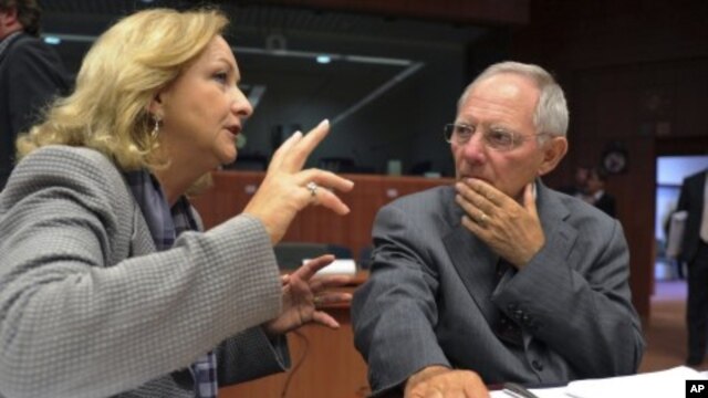 Germany's Finance Minister Wolfgang Schauble, right, talks with his Austrian counterpart Maria Fekter at the start of an Eurogroup meeting at the EU Council in Brussels, May 16, 2011