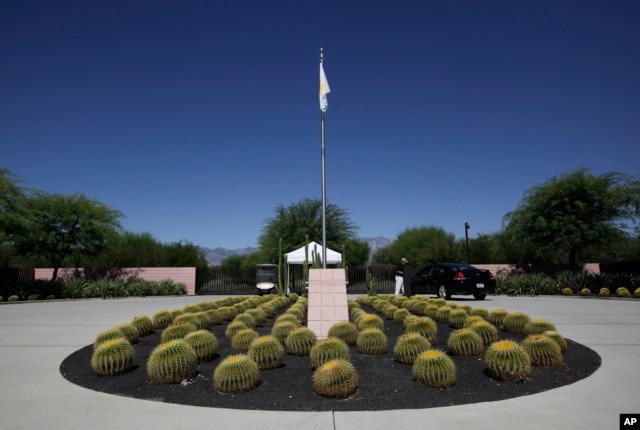 FILE - A security guard talks to a visitor at the entrance to the Annenberg Retreat at Sunnylands in Rancho Mirage, Calif., Wednesday, June 5, 2013.