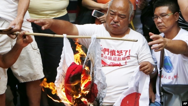 Anti-Japan protesters burn Japanese flags outside the Japanese Consulate General in Hong Kong, September 16, 2012. 