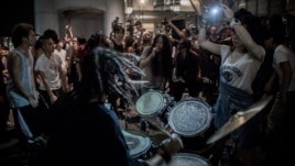 Protesters give a concert at the "Occupy" movement campsite area outside the HSBC bank headquarters in Hong Kong on August 27, 2012.