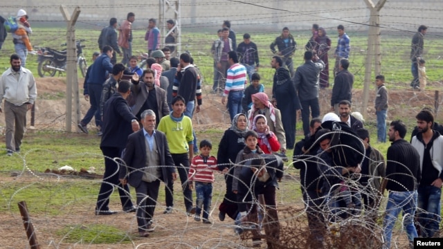 Syrians cross the border from Ras al-Ain to the Turkish border town of Ceylanpinar after an air strike by Syrian government forces, December 3, 2012.