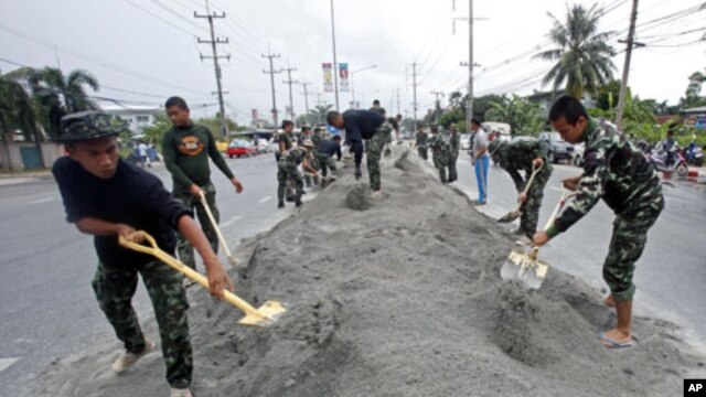 Soldiers make a bank along a street to prepare in case of more flooding in Pathum Thani province, on the outskirts of Bangkok, Thailand, October 12, 2011.