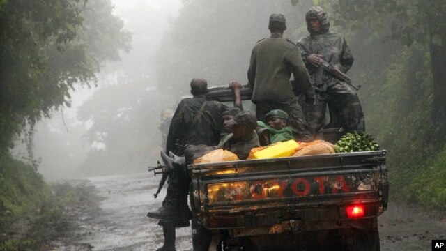 Congolese M23 rebels carry goods in the back of a truck near the Congo-Uganda border town of Bunagana, DRC, December 5, 2012.