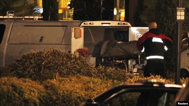 Un médico ingresa a una camioneta uno de los cuerpos de las vítimas durante el tiroteo para trasladarlo a la morgue.