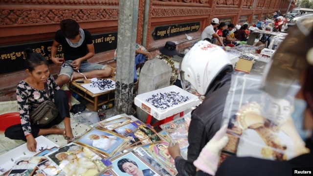 Vendors sell pictures of the royal family, as the country prepares for the funeral of Cambodia's late King Norodom Sihanouk, near the Royal Palace in Phnom Penh, January 31, 2013. 