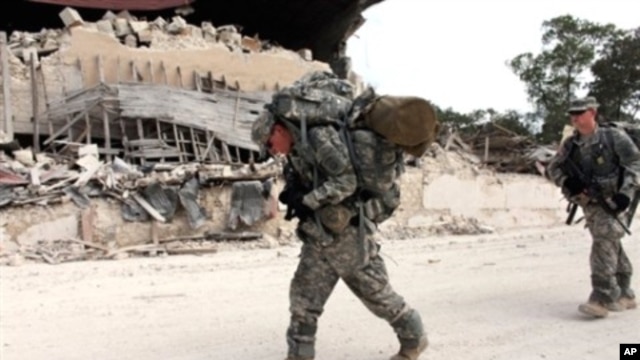 US soldiers of the 82nd Airborne Division walk in streets after leaving the Presidential palace en route to the general hospital in downtown Port-au-Prince, 19 Jan 2010