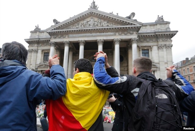 People join hands in solidarity near the former stock exchange following Tuesday's bomb attacks in Brussels, Belgium, March 23, 2016.