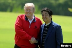 El primer ministro de Japón, Shinzo Abe, saluda al presidente de EE.UU. Donald Trump a su llegada al Mobara Country Club, en Mobara, prefectura de Chiba, en Japón. Mayo 26 de 2019.