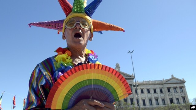 Un activista a favor de los matrimonios entre personas del mismo sexo celebra la decisión de la Cámara de Diputados frente al edificio del parlamento en Montevideo.