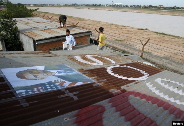People display portraits of U.S. President Barack Obama on the roof of their houses near Phnom Penh Airport November 14, 2012.