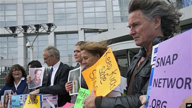 Members of Survivors Network of those Abused by Priests (SNAP) pose in front of the International Criminal Court (ICC) in The Hague, Netherlands, Tuesday, September 13, 2011.
