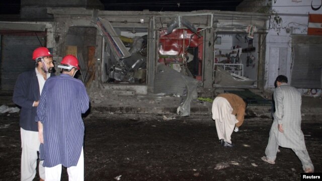 Rescue workers and security officials stand at the site of a suicide bomb attack on the outskirts of Rawalpindi near Islamabad, November 21, 2012.
